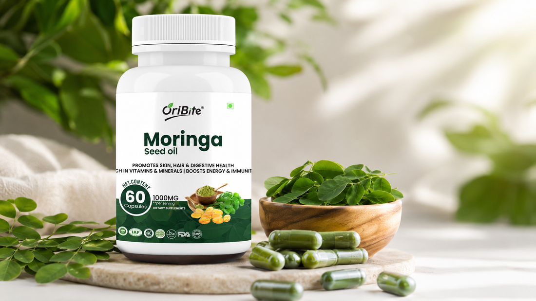 "A white bottle of Oribite Moringa Seed Oil Capsules sitting on a wooden surface next to a small bowl filled with fresh green moringa leaves."