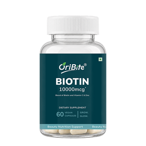 A bottle of OriBite Biotin 10000mcg dietary supplement, featuring a dark teal label and a white cap, containing 60 vegan capsules.