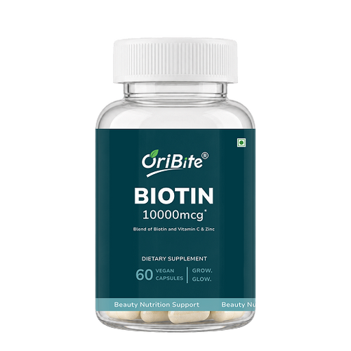 A bottle of OriBite Biotin 10000mcg dietary supplement, featuring a dark teal label and a white cap, containing 60 vegan capsules.
