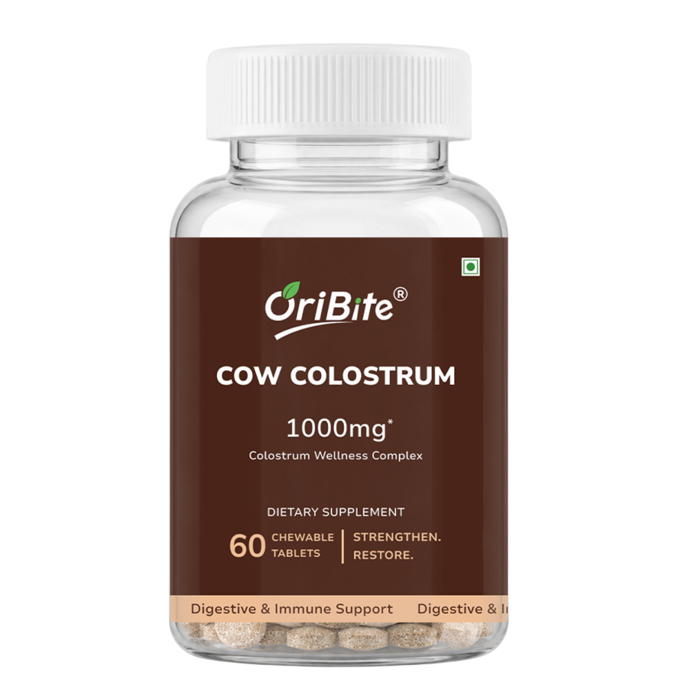 A bottle of OriBite Cow Colostrum 1000mg dietary supplement, featuring a white cap and a dark brown label with white text, containing 60 chewable tablets visible through the clear bottle.